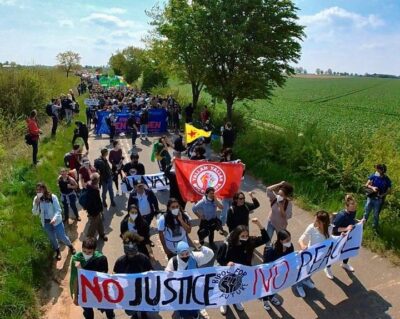 Demo in Lützerath. Erster Block is der BIPoC Block mit dem Banner "No justice No peace" dahinter migrantifa und rwe Enteignen und viele viele Leute.